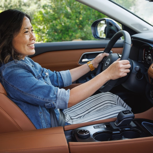 woman utilizing the premium features of NissanConnect inside a Nissan vehicle