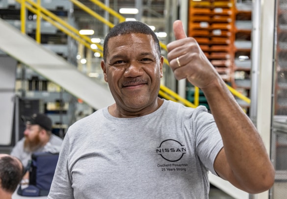 Smiling Nissan employee giving a thumb sign