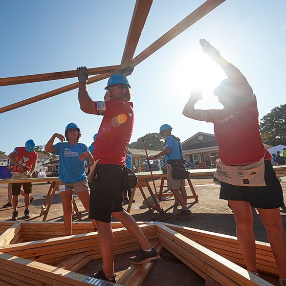 Volunteers building a wooden frame for Habitat for Humanity project, supported by Nissan.