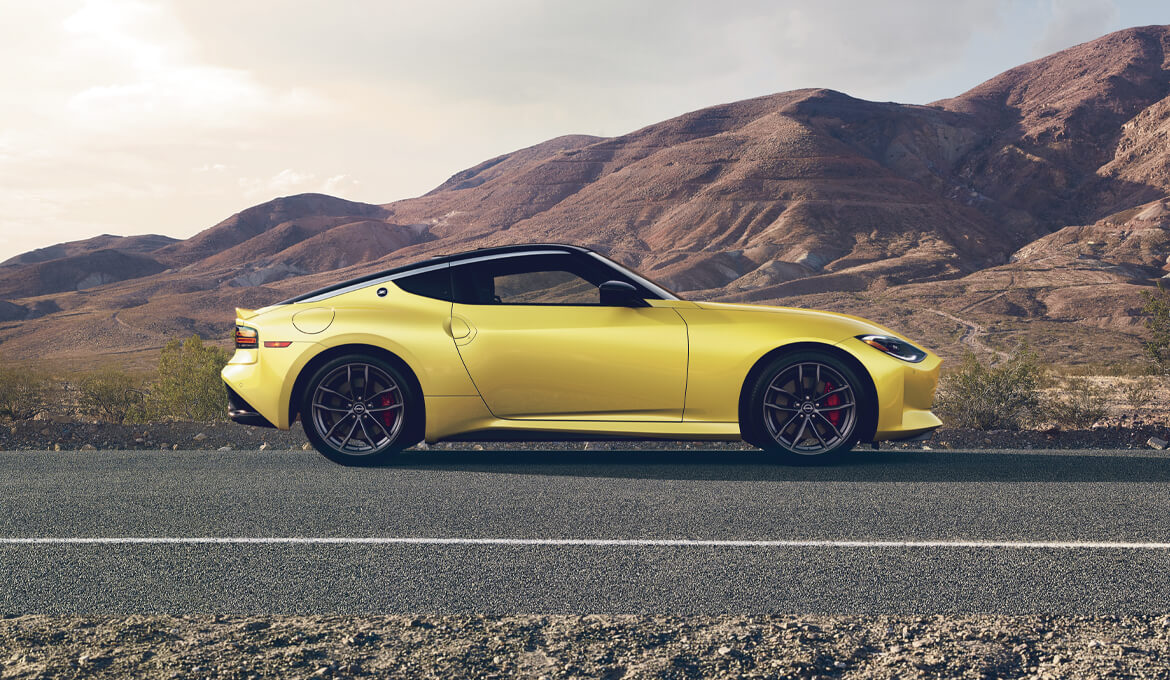 2024 Nissan Z in Ikazuchi Yellow TriCoat paint, in side profile on a desert road