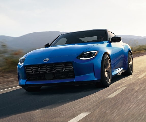 2024 Nissan Z in blue, front view driving down a rural highway